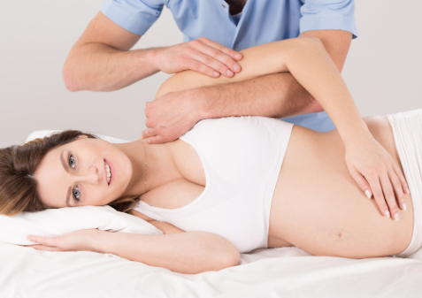 pregnant woman getting adjusted from her chiropractor